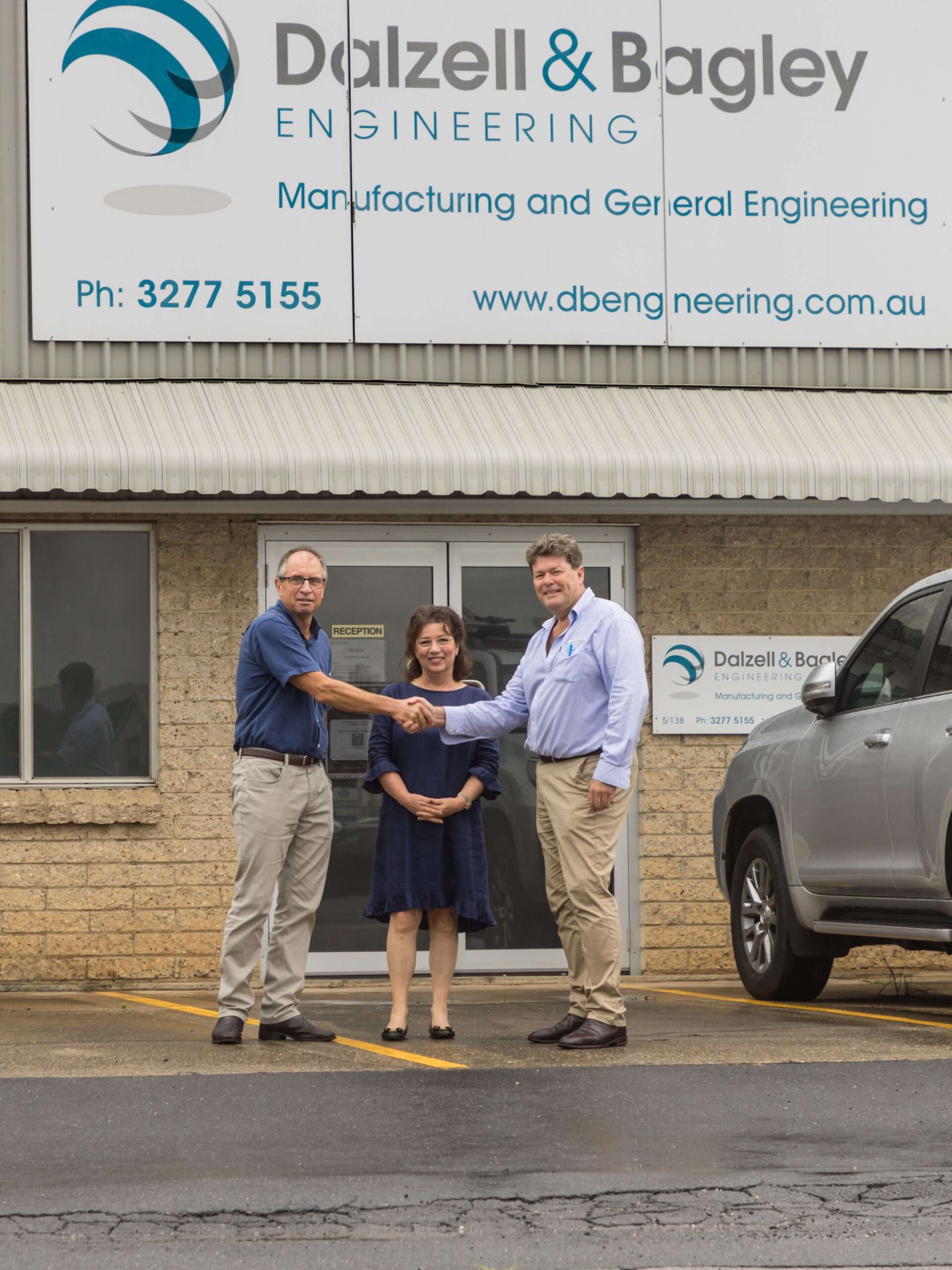 John Drake shaking on the handover with Cameron & Adele George of Dalzell & Bagley Engineering, part of The Drake Group